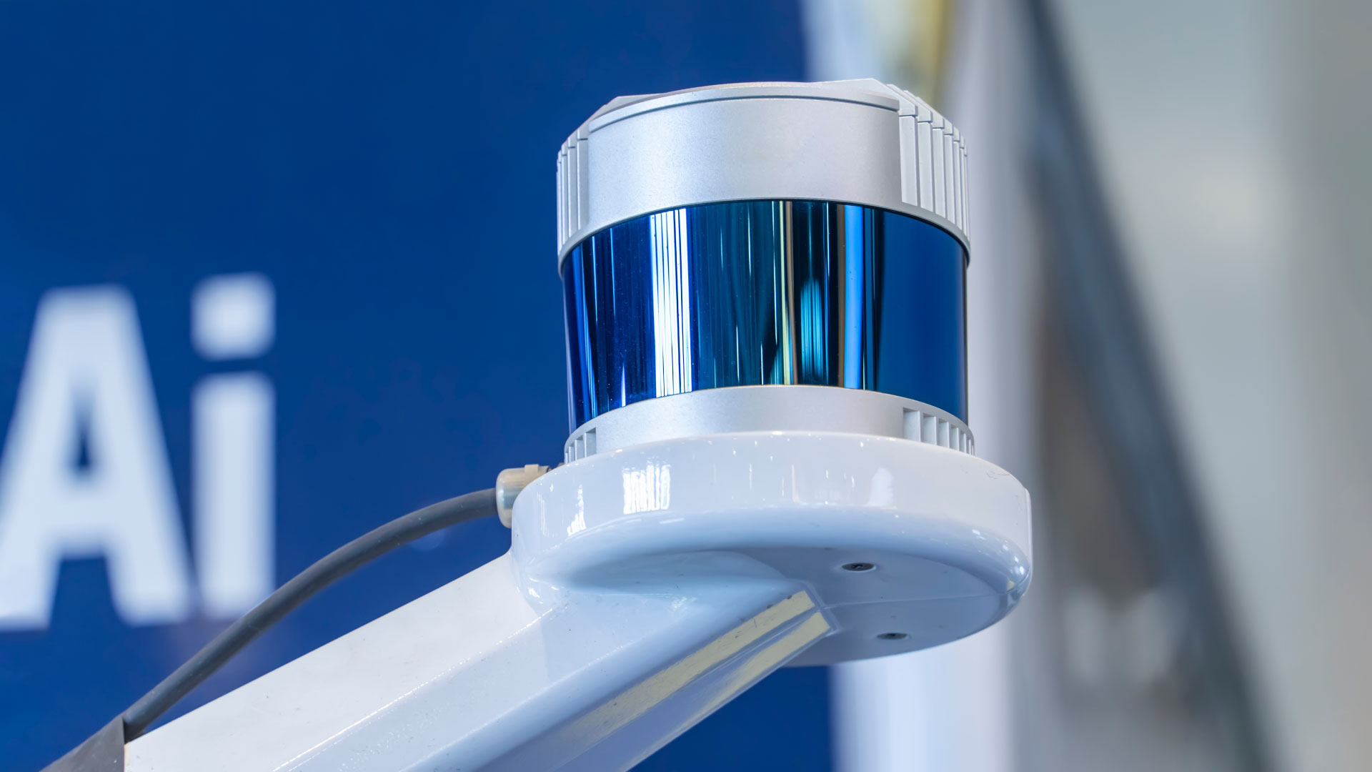 A LiDAR sensor in front of a blue background.