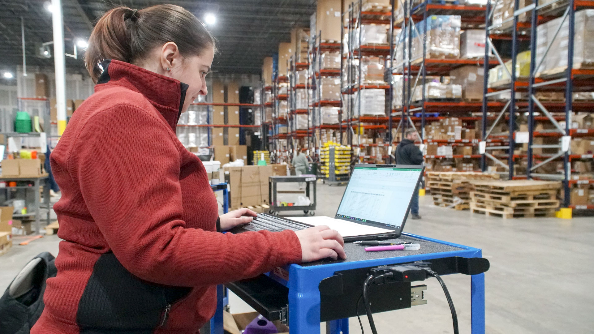 Bailiwick employee reviewing inventory in a warehouse.
