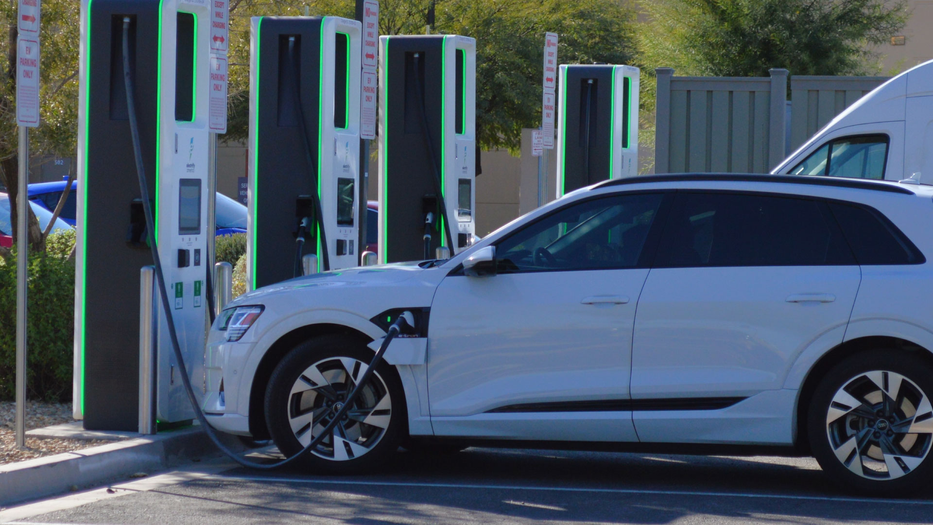An EV car plugged in and charging at a charging station.