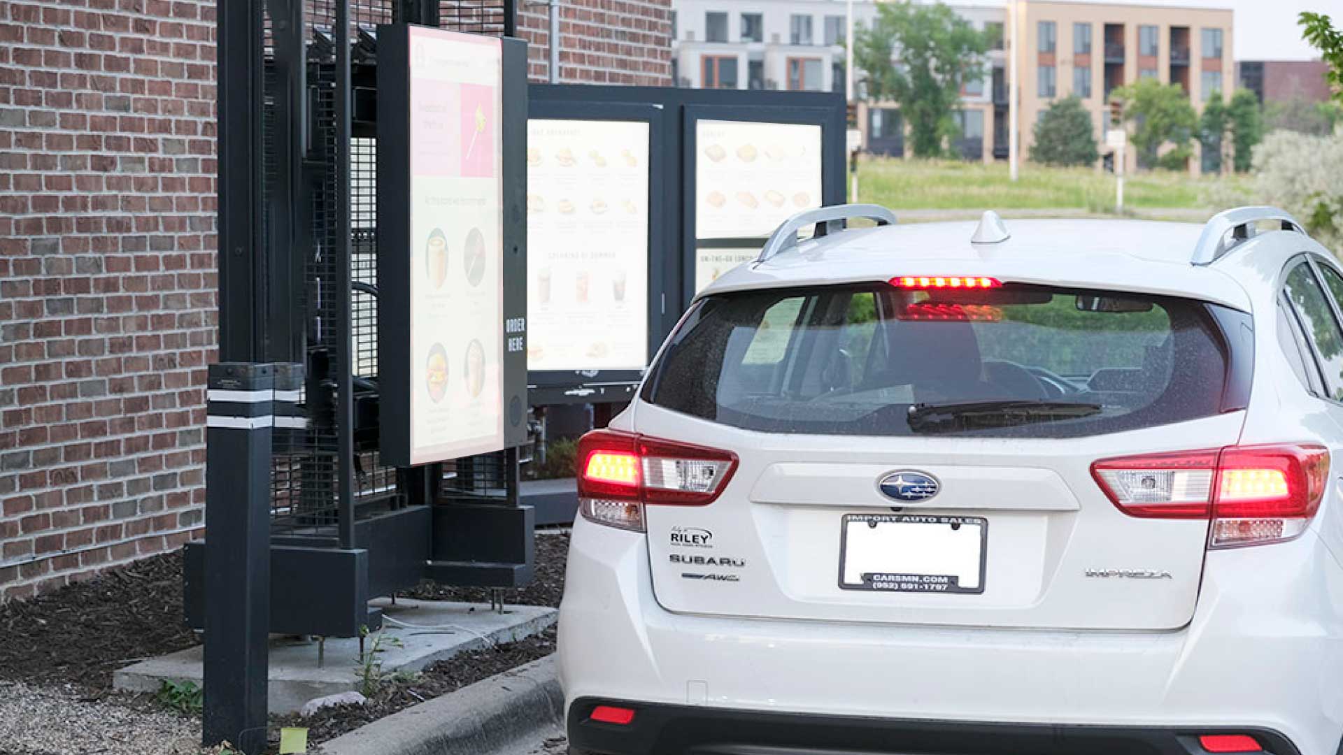 Person at a drive-thru menu ordering food