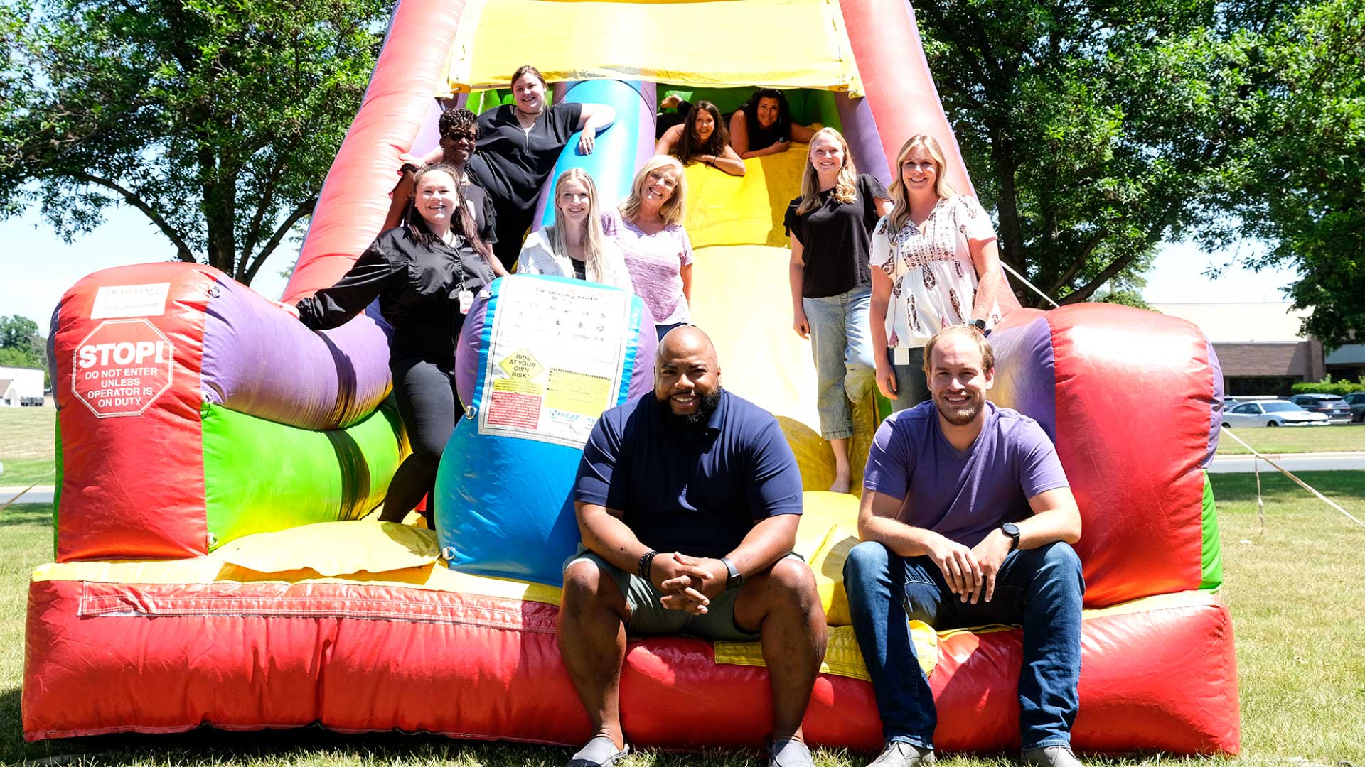 Bailiwick employees siting on an inflatable slide