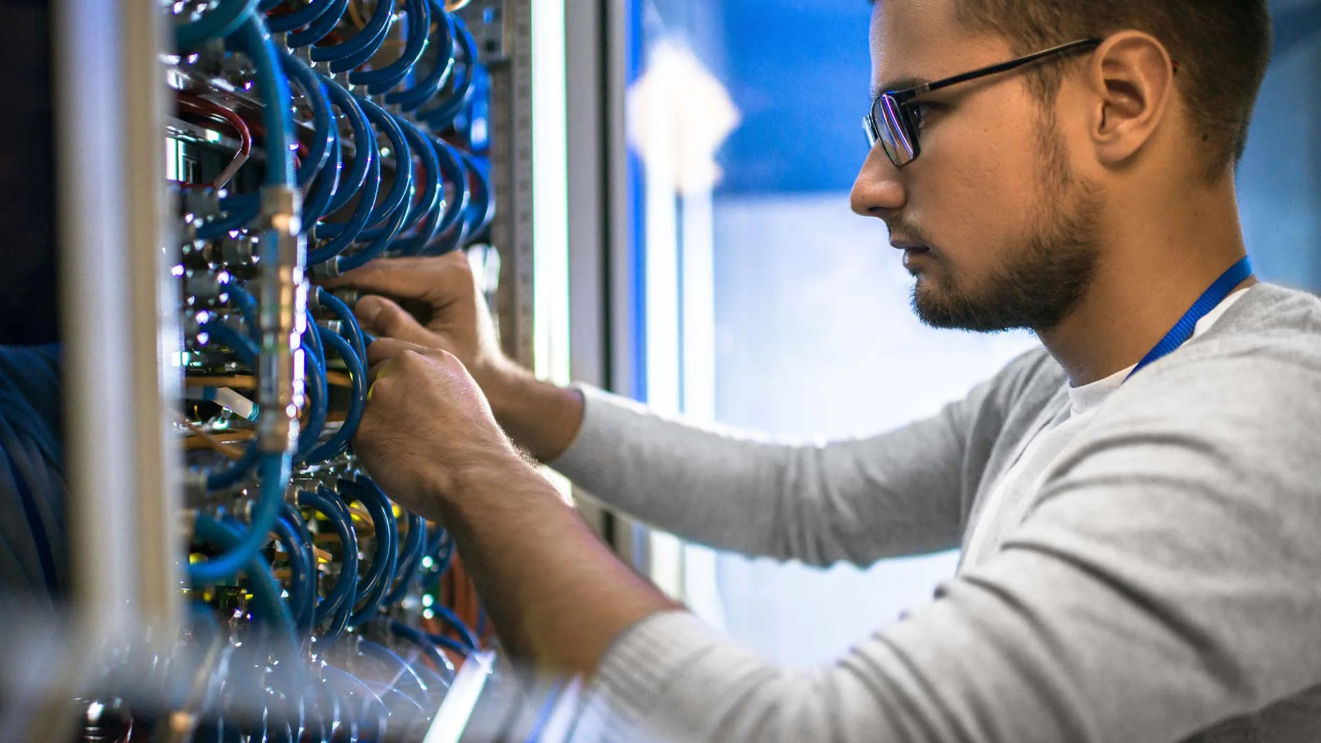 A person working on a networking closet.