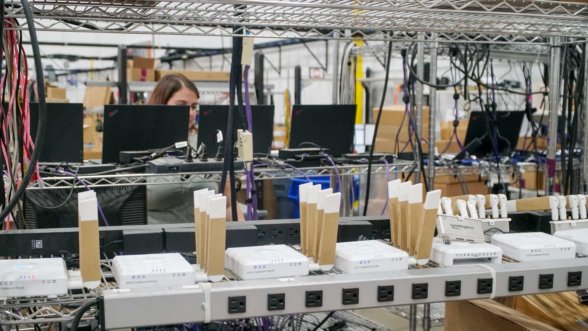 Bailiwick employee at an experienced integration center preparing routers and other devices for large-scale deployments.