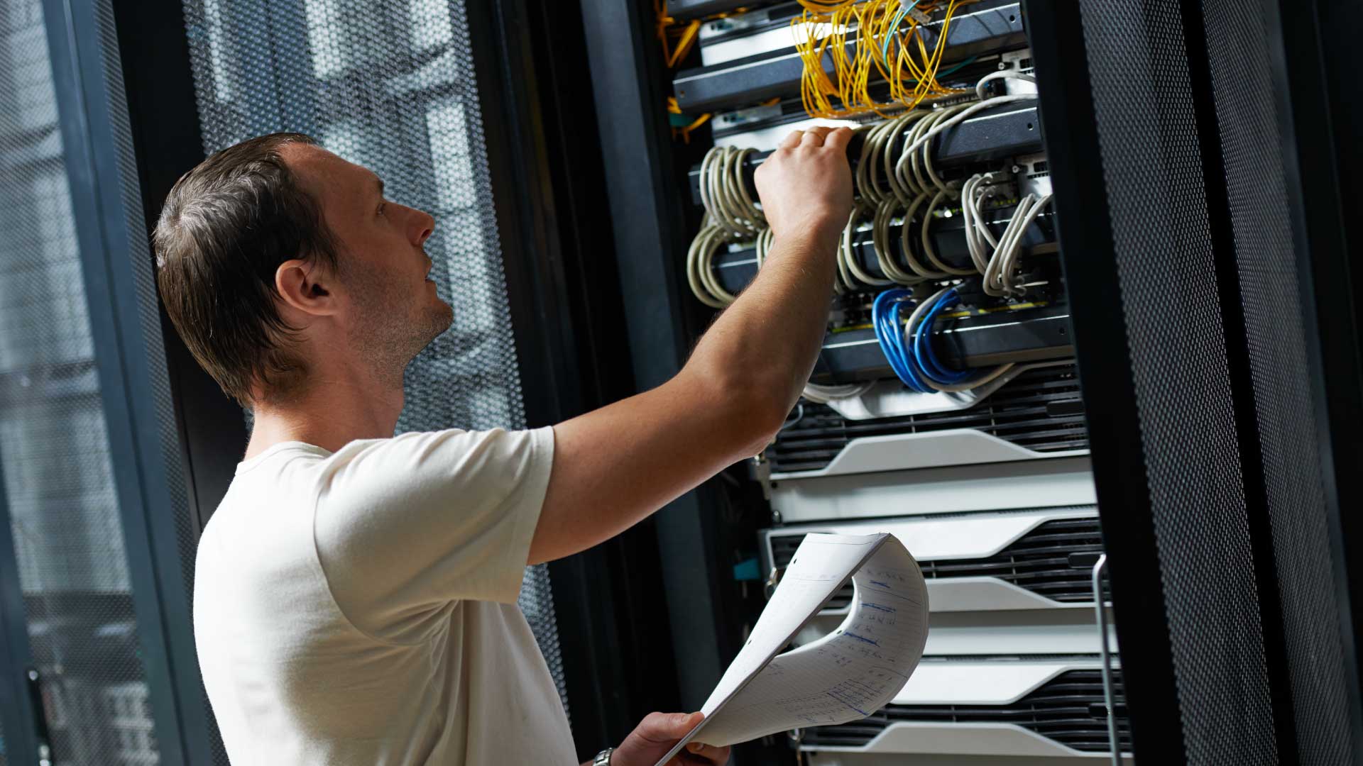 A man evaluates a networking rack.