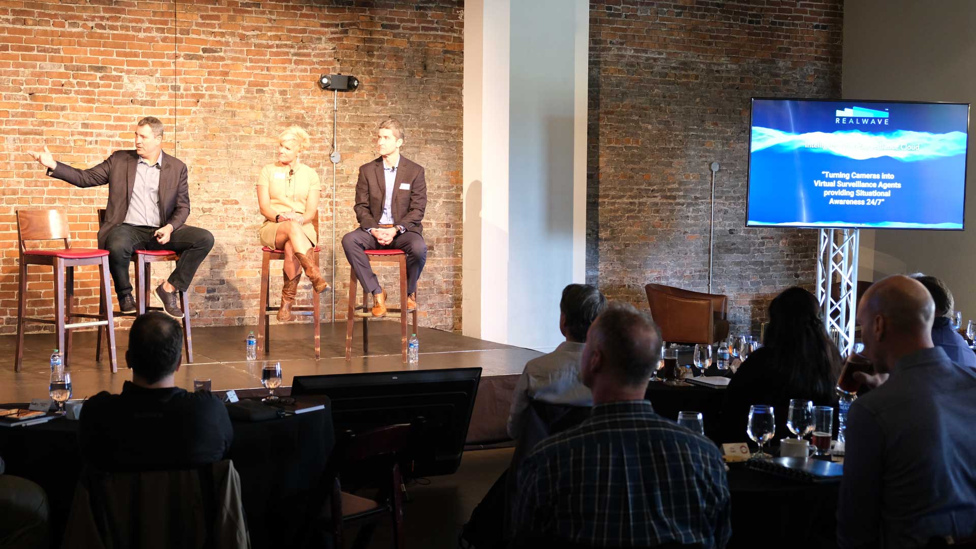 People sitting onstage during a presentation.